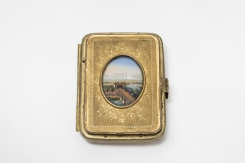 Buch mit goldener Hülle und Miniaturbild eines Stadtpanoramas auf dem Cover.