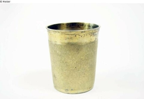 Eine alte, goldene Metallblumentopf auf weißem Hintergrund.