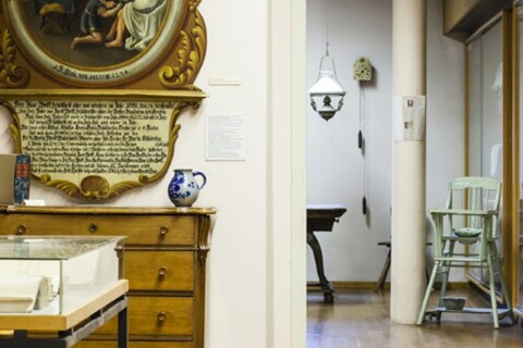 Historische Schätze in einem Museumssaal mit antiken Möbeln und Gemälden.