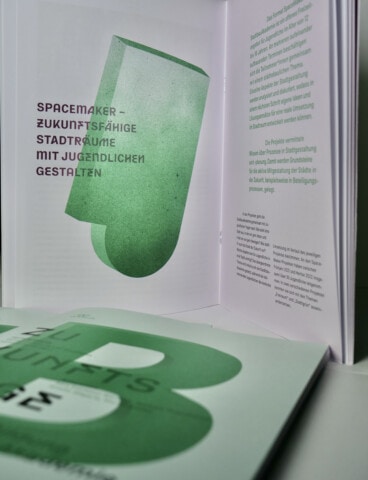 Ein offenes Buch mit grünen Texten und Grafiken, StadtPalais Stuttgart Publikationen.
