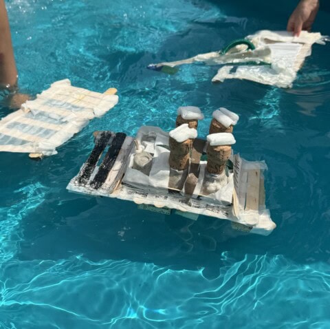 Ein schwimmendes Kunstwerk aus recyceltem Material im Wasser, kreative Umweltkunst.