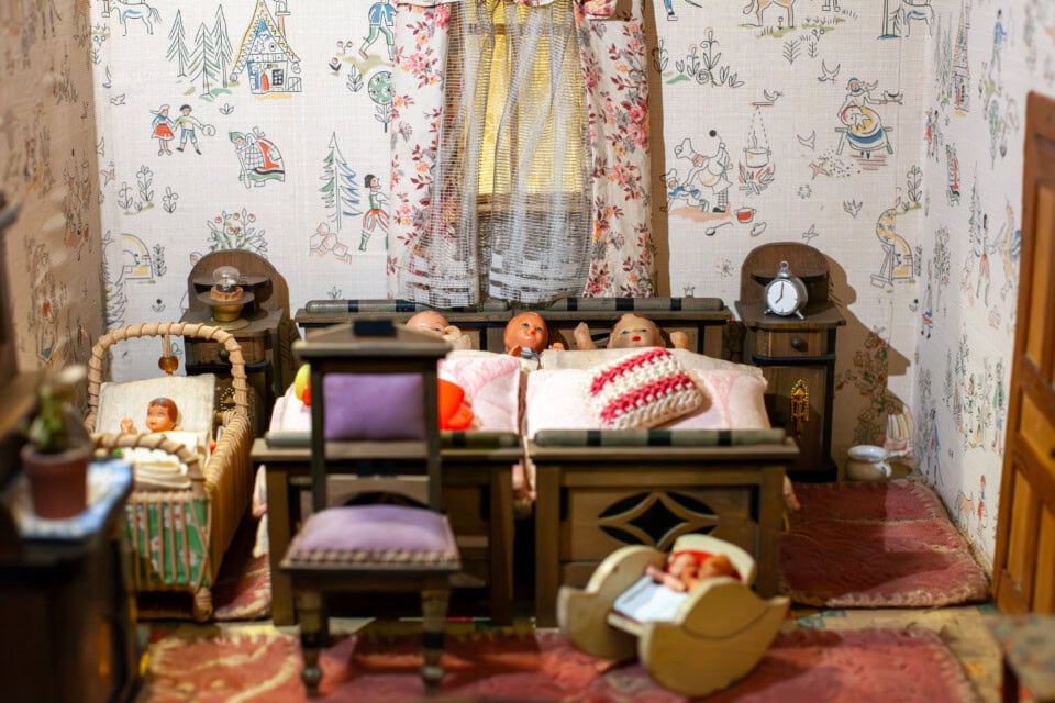 Alte Puppenstube im Heimatmuseum Plieningen mit Bett, Möbeln und Spielzeug.