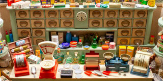 Spielzeugladen mit Miniaturlebensmitteln und Waagen, detailreiche Puppenhaus-Deko.