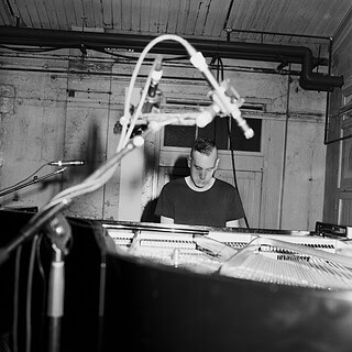 Ein junger Pianist spielt Solo-Klavier bei einem Musikfestival in einem modernen Raum.