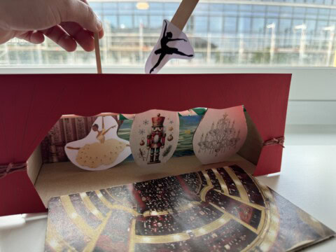 Ein handgefertigtes Marionettentheater mit Ballettfiguren und winterlicher Dekoration.